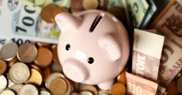 Piggy bank with Australian coins and notes for saving tips.