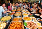 Buffet with diverse dishes and happy diners enjoying food.