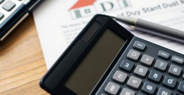 Calculator with property document and pen on a table.