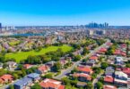 Aerial view of Sydney suburbs with modern homes and parks.