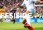 Soccer players in action during an offside situation.