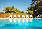 Clear swimming pool with bright blue water and deck chairs.