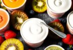 Assorted Australian yoghurts, vibrant fruits, and a spoon.
