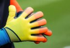 Soccer goalie wearing gloves, ready to catch ball.