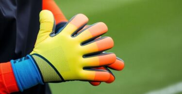 Soccer goalie wearing gloves, ready to catch ball.