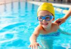 Kid learning to swim with an instructor, Aussie pool.