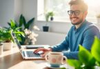 Person working on laptop at home with coffee.