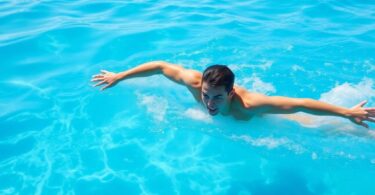 Adult swimmer powering through clear blue water.
