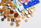 Australian coins and banknotes scattered on a map of Australia.
