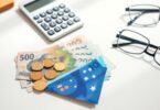 Australian money, calculator and glasses on a desk