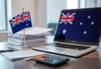 Desk with Australian flag, documents, laptop, and calculator