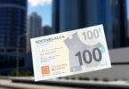 Australian $100 banknote with city background.