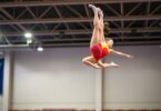 Gymnasts performing a tumbling pass in mid-air.
