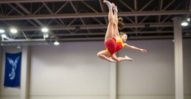 Gymnasts performing a tumbling pass in mid-air.