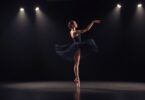 Ballet dancer in black tutu on stage.