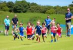 Kids running athletics race with parents cheering nearby