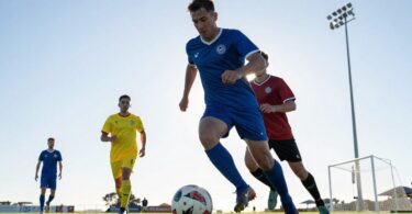 Fremantle 5-a-side football players in action on a green pitch.