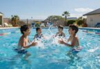 Kids splashing in a bright blue swimming pool.