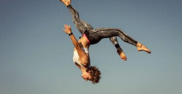 Person mid-air, blue sky, aerial sports Canberra.