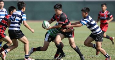 Young rugby league players in action on a green field.