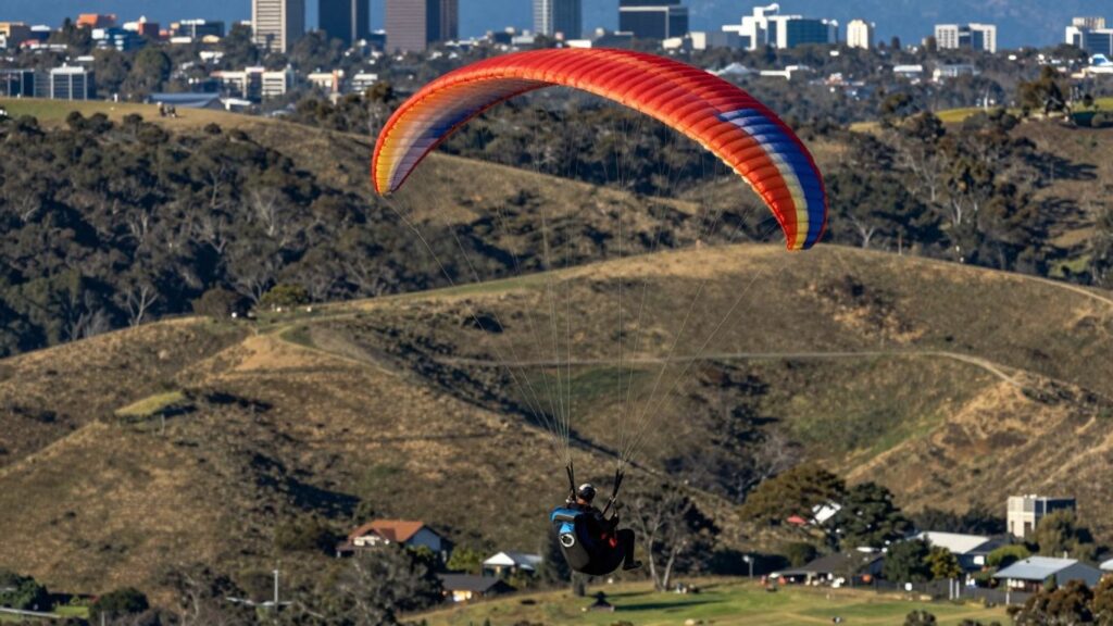 Paraglider flying over Canberra hills