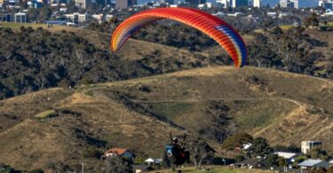 Paraglider flying over Canberra hills