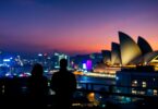 Sydney Opera House at dusk with city skyline.