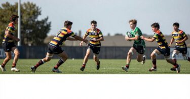 Young rugby league players in action on a field.