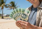 Person holding cash on an Australian beach