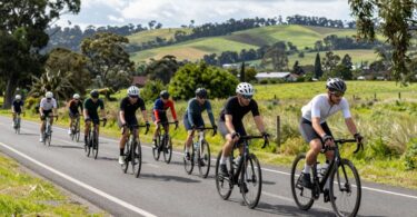 Cyclists riding on a scenic road in Melbourne.