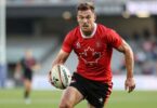 Canadian rugby league player in action on field.