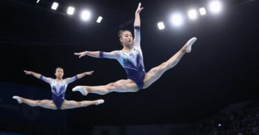 Gymnasts performing aerial acrobatics with intense focus and skill.