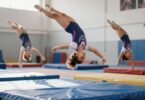 Gymnasts performing flips and tumbles in a bright gymnasium.