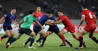 Rugby players in action on a field.