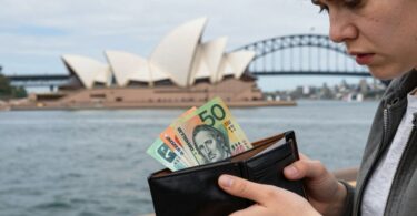 Australian person worried about money near landmarks.