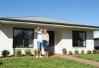Couple holding keys outside a new South Australian home.