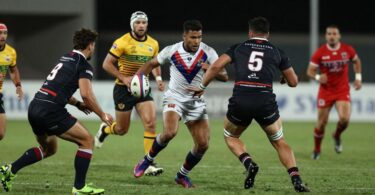 Rugby league players in action on a field.