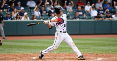 Fresno Eagles baseball player swinging bat on field.