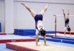 Gymnast performing on balance beam in Auckland.