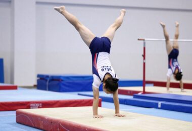 Gymnast performing on balance beam in Auckland.