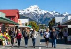 New Zealand street with shops, people, and mountains.