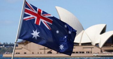 Australian flag with Sydney skyline in background.