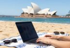 Person earning money online on Australian beach.
