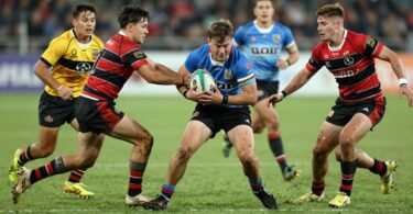 Junior rugby league players in action on a muddy field.
