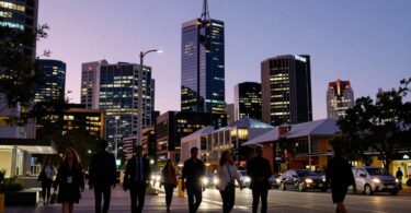 Adelaide cityscape at dusk, professionals walking below.