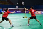 Badminton players in action on a court.