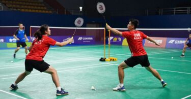 Badminton players in action on a court.