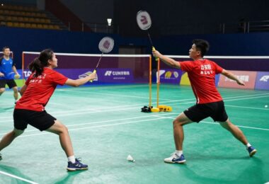 Badminton players in action on a court.