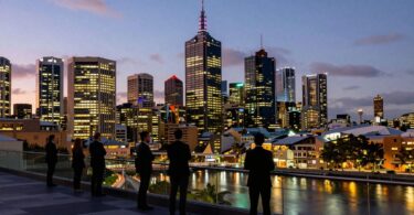 Melbourne skyline at dusk with business professionals.