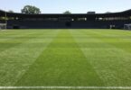 Empty sports field with goalposts under a clear sky.